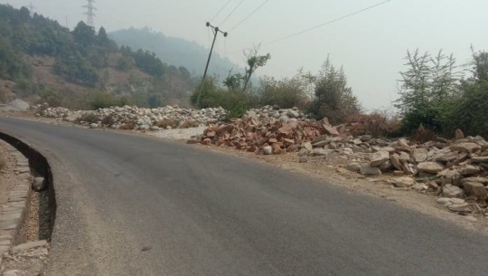 डडेल्धुराका सडक छेउभरी निर्माण सामग्रीको थुप्रो